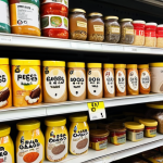 **

A close-up shot of a Malaysian supermarket shelf filled with various food products. The focus is on the nutrition labels on the packaging. Some labels are highlighted with circles around the "Serving Size," "% Daily Value (%DV)," and "Added Sugar" sections. Add a magnifying glass hovering over one of the labels, emphasizing the importance of reading and understanding the information.

**